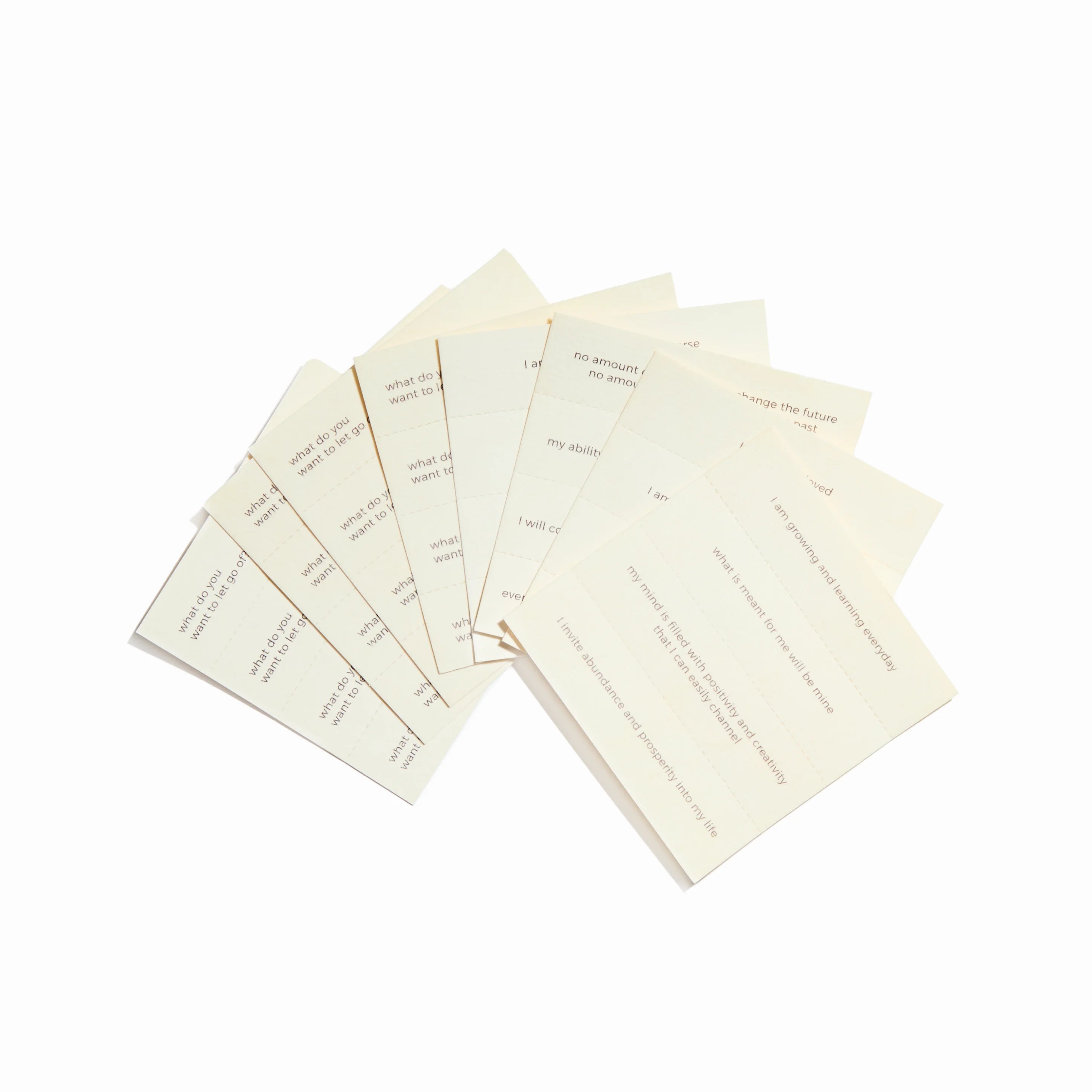 Flat lay of affirmation-inscribed incense papers with visible text and natural paper texture.
