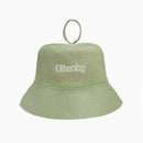 Front view of a light green felt sauna hat with white Othership logo embroidery and top loop.